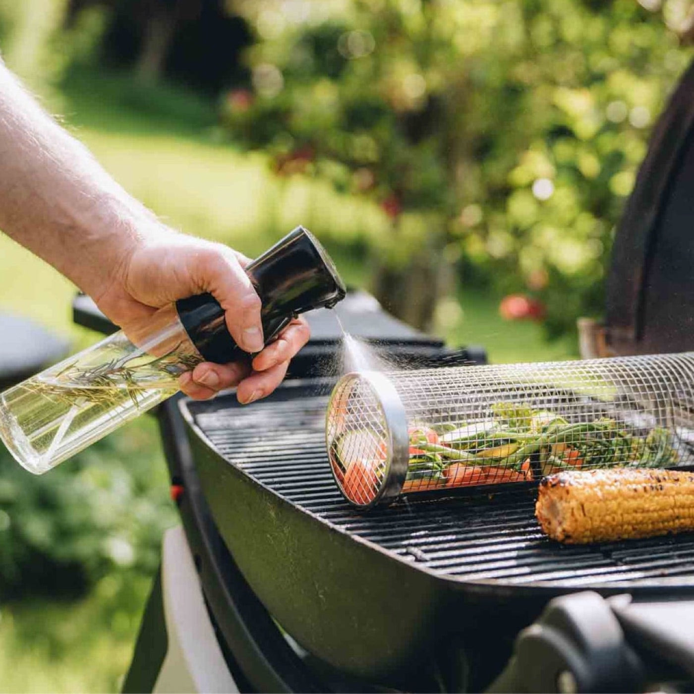 Spraying oil over a grill basket on the grate
